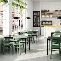 an empty restaurant with green chairs and tables