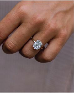 a person's hand with a diamond ring on it