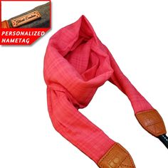 a pink scarf with an orange leather handle on the end, and a name tag for personalized nametag