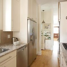 a kitchen with white cabinets and stainless steel appliances