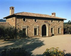 an old brick building with arched windows and two chimneys on the top of it's roof