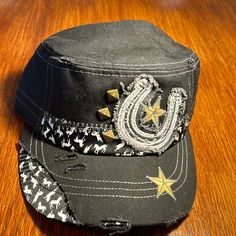 Nwot Pre-Owned Kbethos Hat. Western Distresses Flair. Cadet Style. Black/White With Yellow Stars And 3 Bronze Studs. Elastic In Back. Excellent Condition. ( M-2 ) Distressed Black Hat For Summer, Black Distressed Hat For Summer, Black Distressed Hat One Size Fits Most, Black Distressed Hat One Size, Black Adjustable Distressed Hat, Western Hat Black Or Brown, Black Distressed Adjustable Hat, Black Distressed Visor Hat, Western Goth Hats