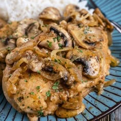 a blue plate topped with chicken, mushrooms and rice