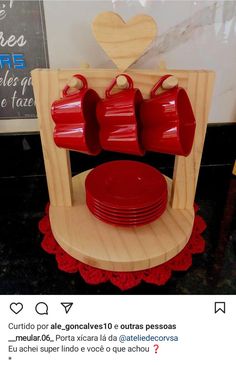 a wooden stand with red cups and plates on it, in front of a sign