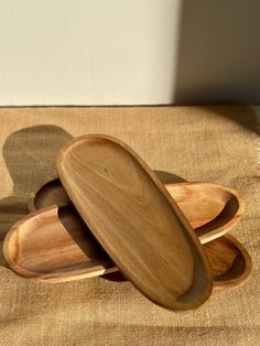 three wooden plates stacked on top of each other in the shape of heart shaped bowls