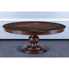 a round wooden table sitting on top of a carpeted floor