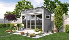 a small gray shed sitting on top of a lush green field