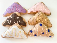 four decorated cookies sitting on top of a white table next to each other in the shape of mountains