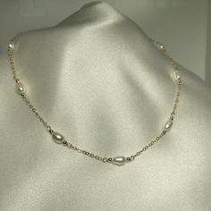 Pretty Diamond cut cable chain that I have spaced with 7 rice shaped pearls with accent beads of 2.5 mm gold fill- each station measures about 1/2" long with the pearl, beads and wire wrap into the chain.  Also offer this design with 1 centered oval (rice shape)- see in options. Updated classic look- 14k gold fill is an excellent material- does not tarnish, superior to plating. Great everyday look, great for layering or on its own- Party necklace, Gift for her Perfect with matching bracelet (see White Pearl Necklace With Satellite Chain, Pearl Satellite Chain Necklace As Gift, Pearl Necklace With Satellite Chain As Gift, Elegant Gold Pearl Necklace With Satellite Chain, Gold Pearl Necklace With Satellite Chain In Dainty Style, Pearl Necklace Bridal, Simple Pearl Necklace, Bridal Pearl Necklace, Freshwater Pearl Jewelry