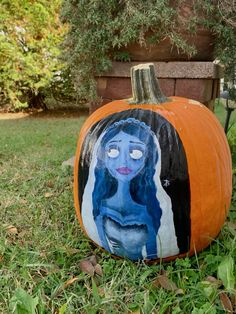 a painted pumpkin sitting in the grass