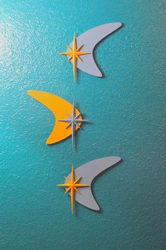 three paper airplanes on a blue surface with yellow and gray stars in the shape of an arrow