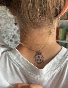 a ladybug tattoo on the back of her neck