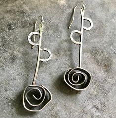 1 3/4 inch sterling swirled rosette. Sterling ear wire. Elegant Hand Forged Swirl Earrings, Elegant Swirl Wire Wrapped Earrings, Elegant Swirl Shaped Hand Forged Earrings, Elegant Handmade Swirl Earrings, Elegant Swirl Ear Wire Jewelry, Elegant Spiral Hand Forged Jewelry, Elegant Hand Forged Spiral Jewelry, Hand Forged Silver Swirl Jewelry, Sterling Silver Swirl Jewelry With Matching Earrings