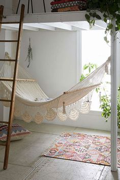 there is a hammock in the room with pink carpet and rugs on the floor