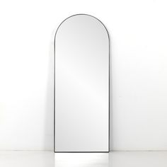 an arched mirror sitting on top of a white counter