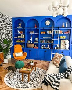 a living room filled with furniture and blue shelves