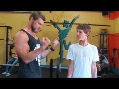 a man standing next to a boy in a gym