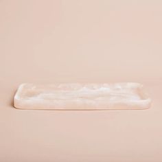 a white rectangular tray on a pink background