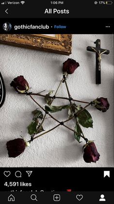 a cross and some flowers on a wall