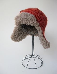 a red and white hat on top of a wire stand