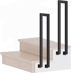 three black metal railings sitting on top of wooden steps in front of a white wall