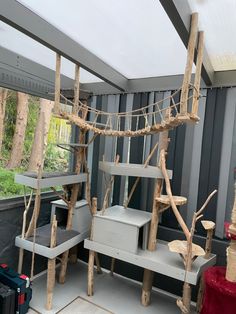 a cat tree house made out of wood sticks and branches