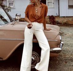 a woman standing next to a car in front of a house