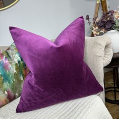 a purple pillow sitting on top of a white couch