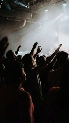 a group of people standing on top of a stage with their hands in the air