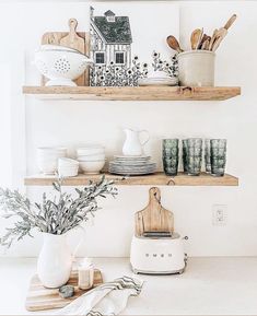 the shelves are filled with dishes and kitchen utensils, such as cutting boards