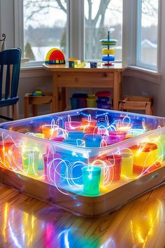 an illuminated play table in the middle of a room with chairs and toys on the floor