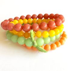 The perfect mix of citrus tones collide in this set of dark coral, light tangerine, fern green & golden yellow vintage beads. Bead sizes in this set are 10mm at the largest width. This stacking arm party set features 4 separate bracelets strung on a stretch material. One size fits most. Because the beads we use are vintage & sometimes very limited, beads may vary slightly from the design shown but the look of the overall design & color way will be the same. Leetie stack & stretch bracelets look Orange Bohemian Beaded Bracelets With 8mm Beads, Yellow Stackable Beaded Bracelets, Orange Stackable Jewelry With Round Beads, Orange Stackable Round Bead Jewelry, Adjustable Orange Stackable Beaded Bracelets, Adjustable Stackable Orange Beaded Bracelets, Orange Stackable Bracelets With Round Beads, Stackable Orange Round Beaded Bracelets, Vintage Adjustable Green Beaded Bracelets