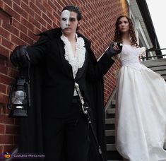 a man and woman dressed up in costumes standing next to each other on the steps