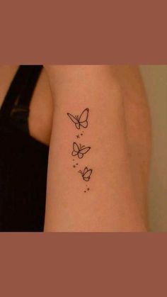 a woman's arm with three butterflies tattoo on the left side of her arm