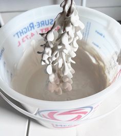 a white bowl filled with liquid sitting on top of a counter