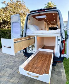 the back end of a van with an open bed and drawers on it's side