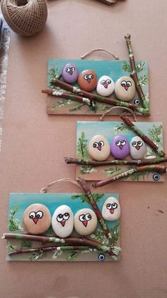 three birds are painted on rocks with sticks and some twigs in front of the photo