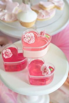 three heart shaped cupcakes sitting on top of a cake plate