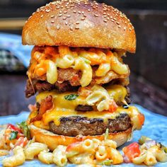 a cheeseburger with macaroni and cheese is on a blue platter