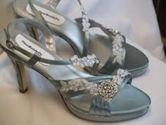 a pair of blue high heeled shoes with flowers on them