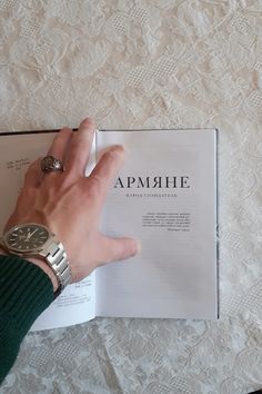 a person's hand on top of an open book with the word apmhre written in it