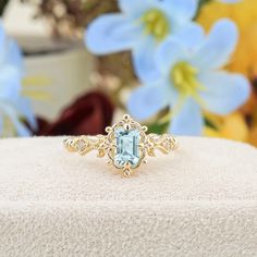 a ring with an aqua topazte surrounded by flowers