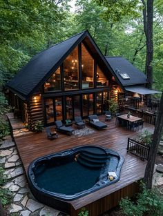 a large hot tub sitting in the middle of a wooden deck next to a house