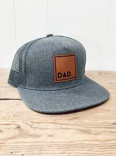 "Da Da Snapback hat- The perfect gift for Father's Day, Christmas, Birthday, Pregnancy Announcement, New Dad hat or just to let the hat loving Father in your life know he's THE BEST! These caps have a thick stitch around the patch for added durability and style!  You know he's the BEST, so why not show him with one of his favorite things- a hat! Snapback Hats that Dads are sure to LOVE! Show the Dad in your life how much he means to you with these awesome hats! These are stylish and durable to hold up to the Dad life! Adjustable Snapback style. *Richardson 112 style available upon request and made to order so turn around time for that style is about 5-7days.  Sizing: Adult: one size fits most 22\" to 23.5\" circumference  56cm to 60 cm 2.75'' Brim Length; 4.5''x7.0''    Any questions or su Birthday Pregnancy Announcement, Dad Pregnancy Announcement, Loving Father, Black Trucker Hat, Pregnancy Reveal, Dad Life, New Dads, Dad Hat, Leather Patches