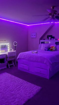 a bedroom with purple lights on the ceiling and a bed in front of a desk