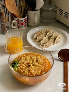 a bowl of noodles with broccoli and carrots next to other food items