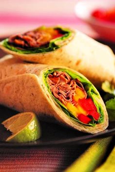 two burritos with meat and vegetables on a plate