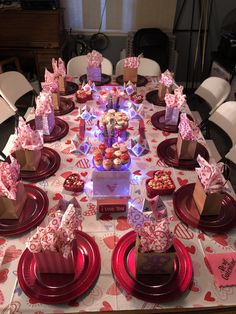 a table set up for valentine's day with cupcakes and candy