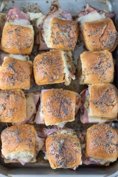 a pan filled with sliders covered in meat and cheese