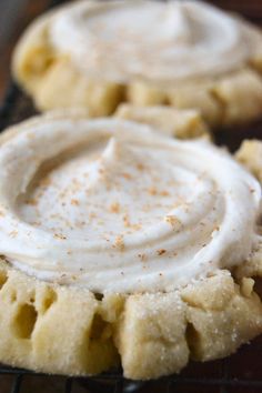 two cookies with whipped cream on top sitting on a cooling rack